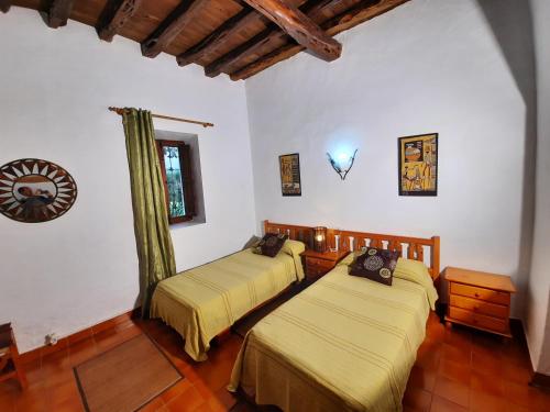 Duas camas num quarto com paredes brancas e pisos em madeira em Can Joan Yern em Sant Joan de Labritja