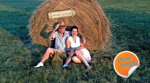 a man and woman sitting in front of a haystack at B B Guesthouse TIHANY in Tihany