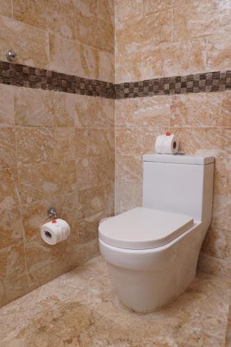 a bathroom with a toilet and two rolls of toilet paper at Sybaris Suites & Residences in Juan Dolio