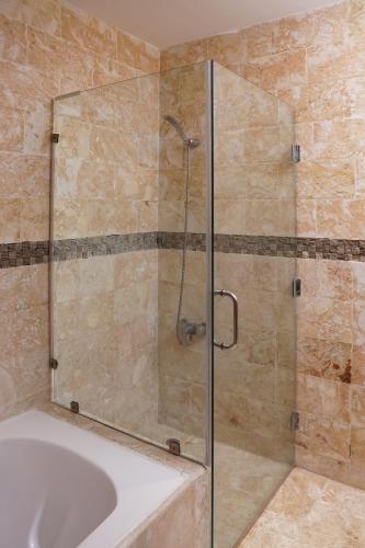 a shower with a glass door in a bathroom at Sybaris Suites & Residences in Juan Dolio