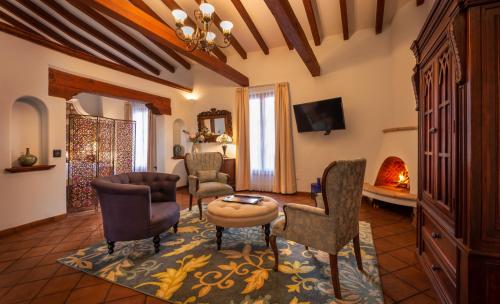 a living room with chairs and a table and a fireplace at Hotel Boutique Casa Colorada in Pátzcuaro