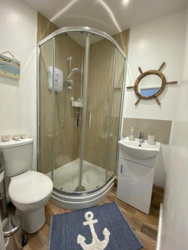 a bathroom with a shower and a toilet and a sink at Margate Seaside Retreat in Margate