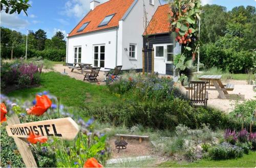 a house with a garden with flowers in front of it at DE DUINDISTEL Bed by the Sea in Dishoek