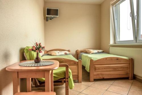 a room with two beds and a table and a table at Pokoje gościnne Jędruś in Mielno