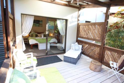 a screened in porch with a view of a bedroom at MALI Boutique Lodge & Tube 'n Axe Budget Accommodation in Stormsrivier
