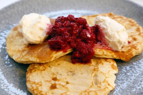a plate of pancakes with raspberry jam and ice cream at Quorn Grange Hotel in Loughborough