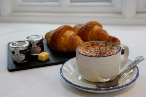 a cup of coffee and a plate of croissants at Quorn Grange Hotel in Loughborough