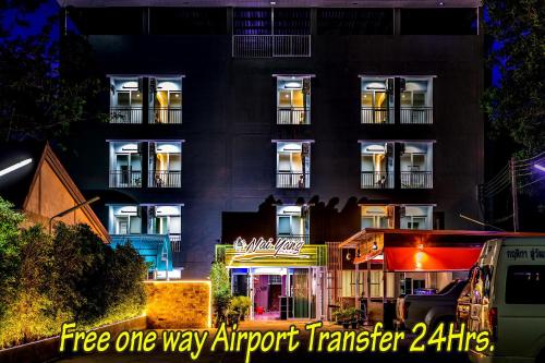 a tall building with lights in front of it at Naiyang Place - Phuket Airport in Nai Yang Beach
