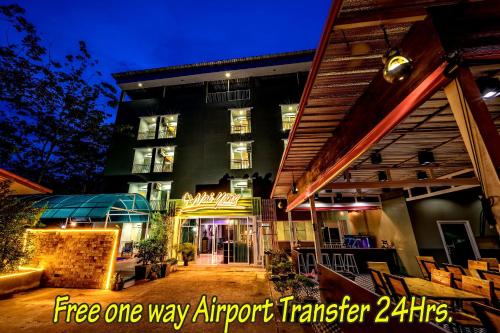 a building with a patio and a building with a sign at Naiyang Place - Phuket Airport in Nai Yang Beach