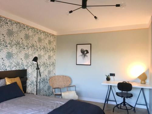 een slaapkamer met een bed en een bureau met een lamp bij ROOM 10 in Valmiera