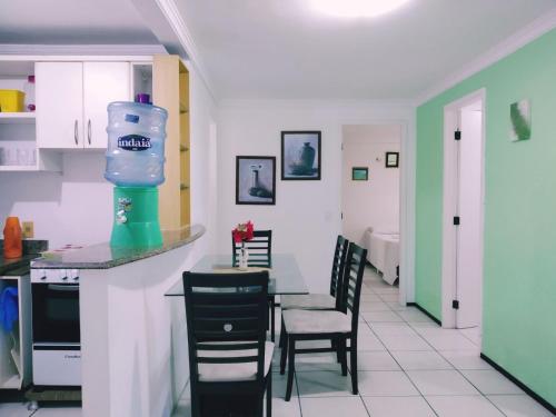 una cocina con mesa con sillas y una botella de agua en Porto de Iracema- Ferias Temporada Fortaleza, en Fortaleza
