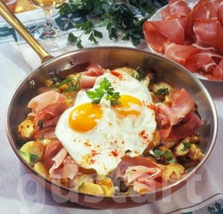 een kom met eten, eieren en ham, op een tafel bij Koloska apartmanház in Balatonfüred