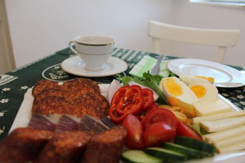 een bord met eieren en groenten op tafel bij Koloska apartmanház in Balatonfüred