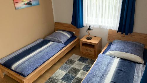 a bedroom with two beds and a table with a lamp at Strandnahe, familienfreundliche Ferienwohnung auf Usedom in Koserow in Ostseebad Koserow
