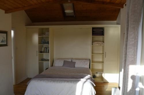 a bedroom with a bed in a room with shelves at Rocklands Cottage in Kinsale