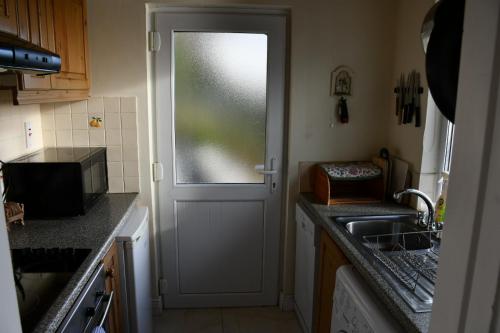 a kitchen with a door with a window and a sink at Rocklands Cottage in Kinsale