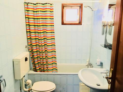 a bathroom with a toilet a sink and a bath tub at Casa dos Azulejos in Matosinhos