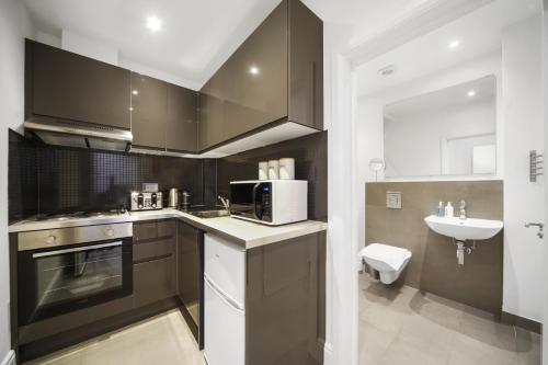 a kitchen with a microwave oven and a sink at Studio Apartment by Homely Stays in London