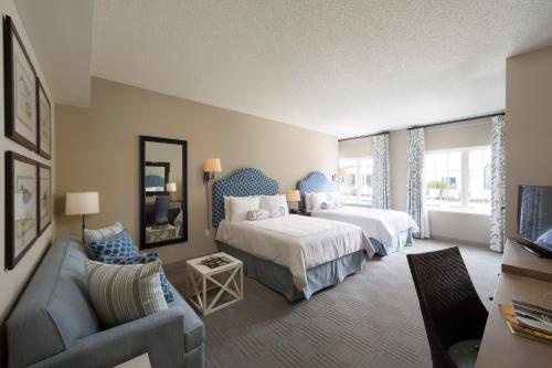 a hotel room with two beds and a couch at The Inn by Sea Island in Saint Simons Island