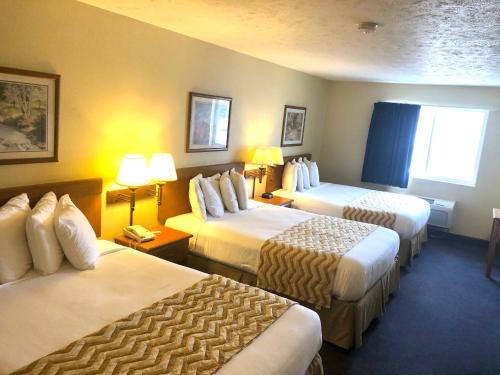 a hotel room with two beds and two lamps at Travelodge by Wyndham Grand Island in Grand Island