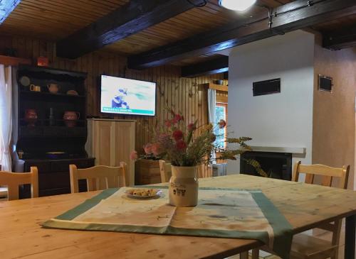 a dining room with a table and a television at Chata Boca Salašky in Nižná Boca