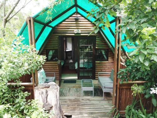 a small wooden cabin with a blue roof at MALI Boutique Lodge & Tube 'n Axe Budget Accommodation in Stormsrivier