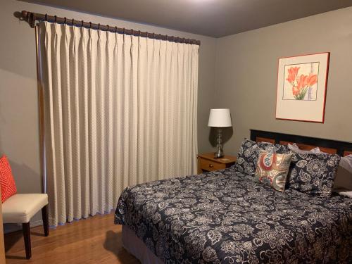 a bedroom with a bed and a window with curtains at Der Sportsmann Suites in Leavenworth
