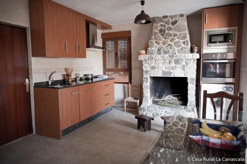 a kitchen with a stone fireplace in a room at Casa Rural La Carrascala in Zamora