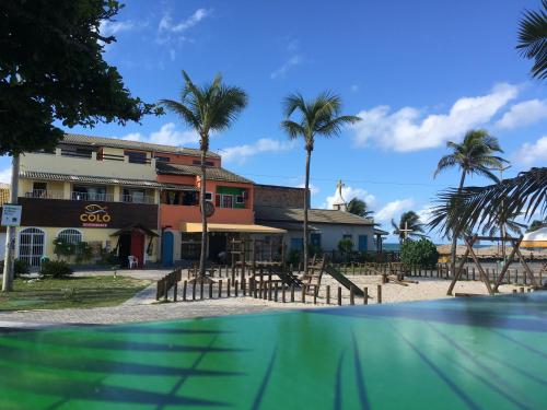 een resort met een zwembad voor een gebouw bij Apartamentos da Coló in Arembepe