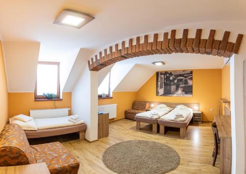 a living room with yellow walls and a wooden staircase at Penzion Hluk in Hluk