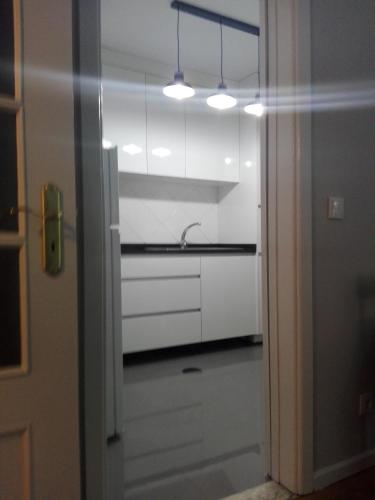 a kitchen with white cabinets and a sink at Secondlove in Porto