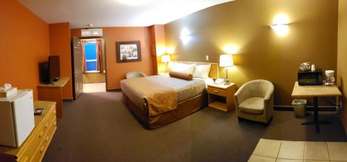 オソヨースにあるAvalon Innのベッドとテレビが備わるホテルルームです。