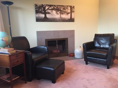 a living room with two chairs and a fireplace at Stone Hill Overlook in Hermann