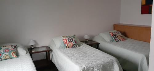 Habitación con 2 camas individuales y 2 lámparas. en Apartment con terraza 1 piso por escalera en Buenos Aires
