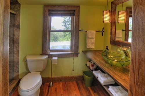 a bathroom with a toilet and a sink and a window at Stone Hill Overlook in Hermann