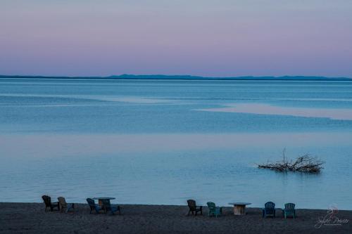 a group of chairs and tables on the beach at Domaine sur une plage in Saint-Félicien