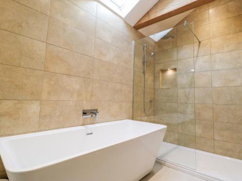 a bathroom with a white tub and a shower at The Hayloft in Harrogate