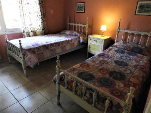 1 dormitorio con 2 camas y mesa con lámpara en Shanti-om en Sierra de la Ventana