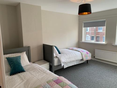 a bedroom with two beds and a window at Fab City Centre Pad, walking distance to City Centre in Belfast