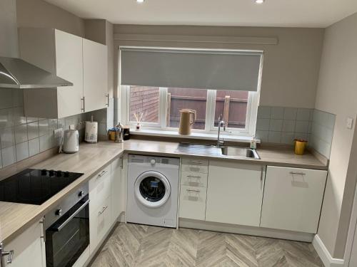 a kitchen with a sink and a washing machine at Fab City Centre Pad, walking distance to City Centre in Belfast