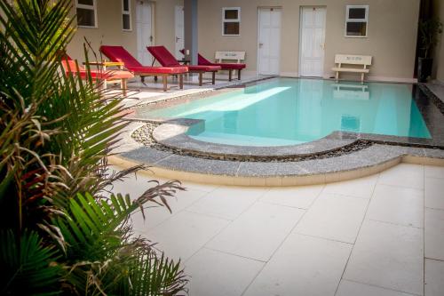 a swimming pool in a building with red chairs at Mui Ne Hills Budget Hotel in Mui Ne