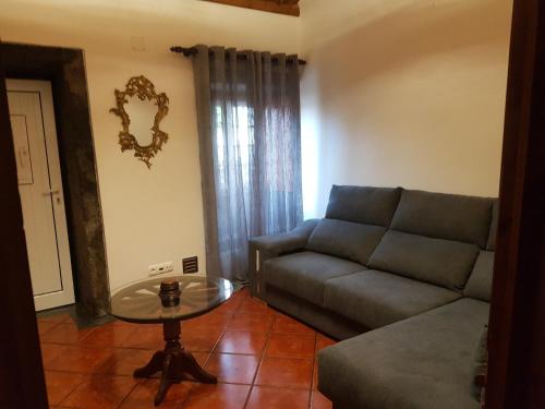 a living room with a couch and a glass table at Golden House in Angra do Heroísmo