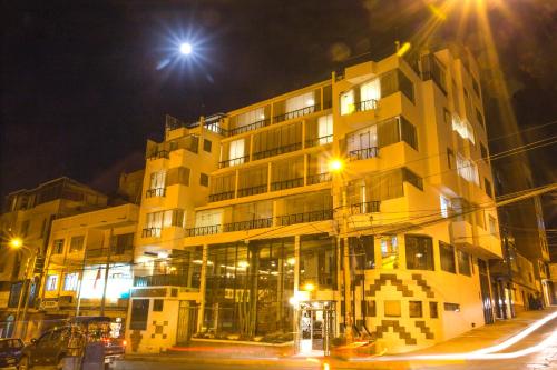 a yellow building at night with a street at Conde de Lemos Hotel in Puno