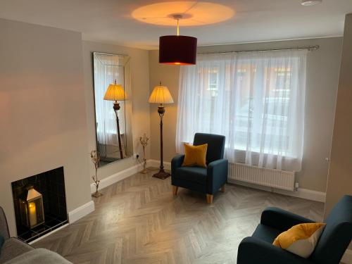 a living room with a fireplace and a blue chair at Fab City Centre Pad, walking distance to City Centre in Belfast