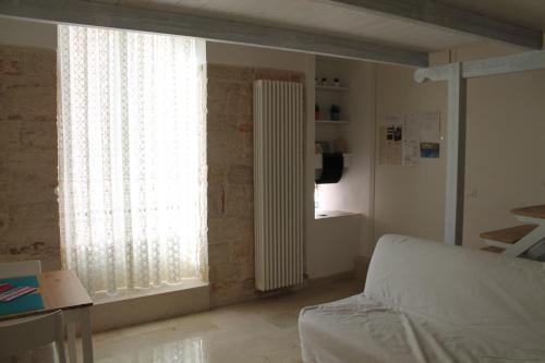 uma sala de estar com um sofá e uma janela em B&B piazza Garibaldi em Santeramo in Colle