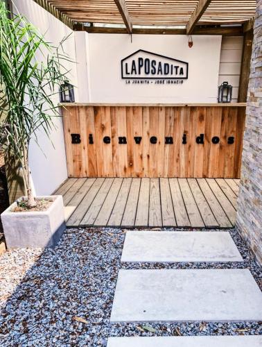a store with a wooden door and a sign at La Posadita in José Ignacio