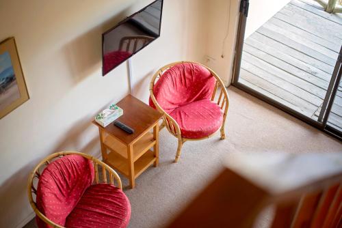 a room with two chairs and a table and a mirror at Karribank and the Karri On Bar in Porongurup