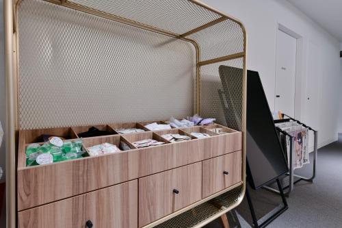 a wooden dresser with many boxes on it at Vessel Inn Keisei Tsudanuma Station in Narashino