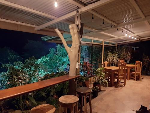 a restaurant with a fake tree in the middle of a garden at Marita's Bed and Breakfast in Nuevo Arenal