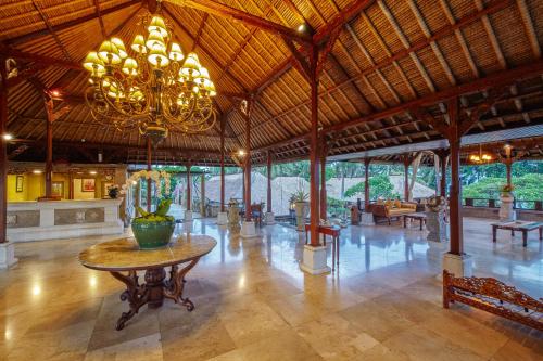 a large room with a table and a chandelier at Puri Bagus Lovina in Lovina